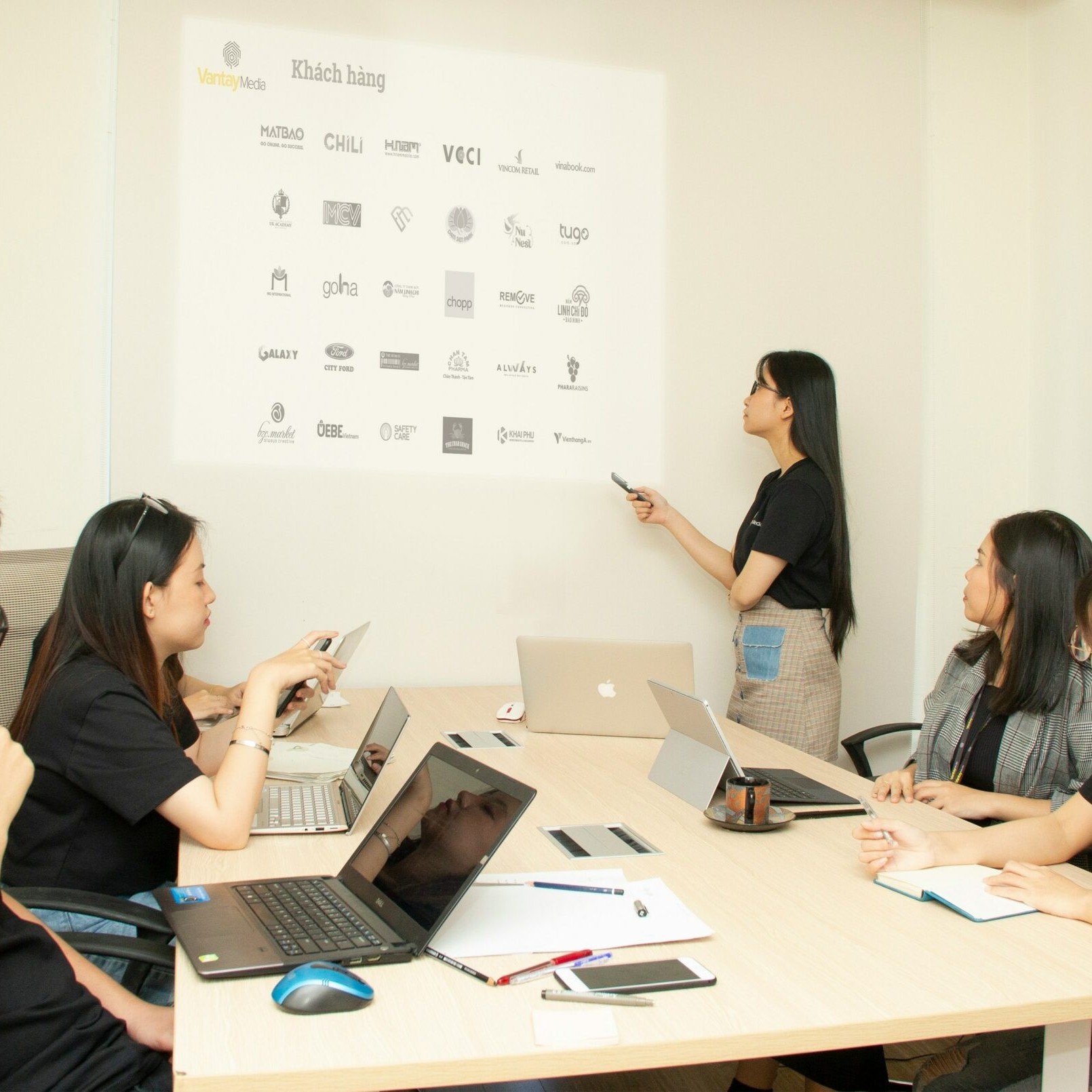 une femme debout présente un tableau face à son équipe